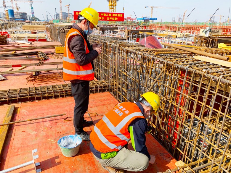 3.中建三局华东公司杭州萧山机场项目建设者正在对照图纸给套管定位_conew1